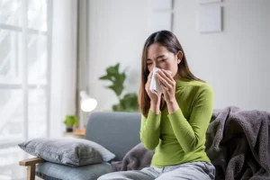 Heartland Heating & Cooling—A sick woman sneezing in her home in Springfield, IL.